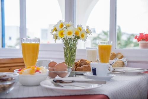 a table with breakfast foods and drinks on it at Hotel Olympia in Karterados