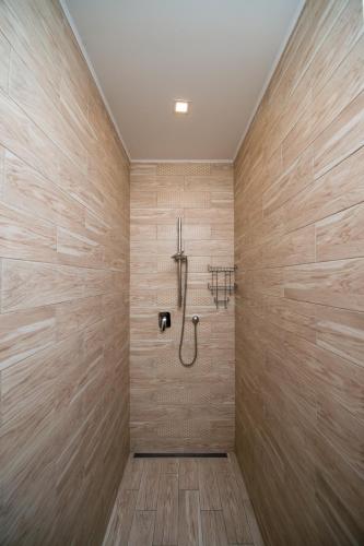 a bathroom with a shower with wooden walls at light hotel & hub in Kyiv