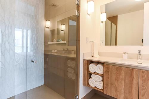 a bathroom with a shower and a sink and a mirror at Marina Pez Vela Villas in Quepos