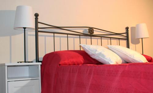 a bed with a red blanket and white pillows at Antico Borgo Casalappi in Campiglia Marittima