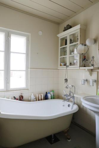a white bathroom with a tub and a sink at 1800's Townhouse in Loviisa
