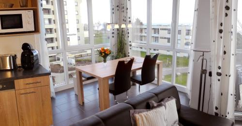 ein Wohnzimmer mit einem Tisch und einem großen Fenster in der Unterkunft Apartment Leuchtturm 16 in Großenbrode