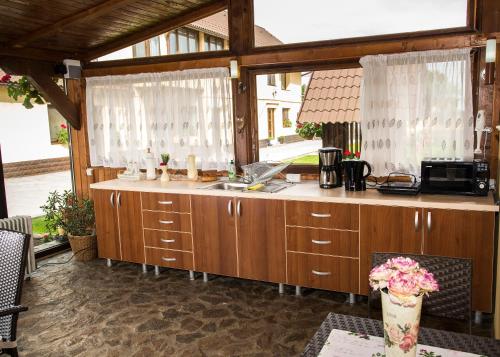 a kitchen with wooden cabinets and a counter top at Casa Antonia Homestay in Şura Mică