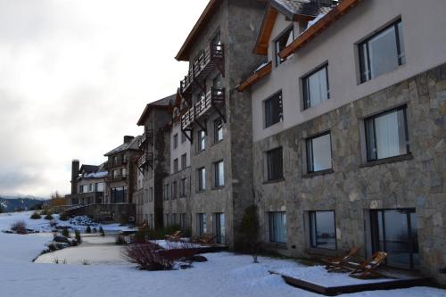 a row of buildings with snow on the ground at Loi Suites Chapelco Hotel in San Martín de los Andes