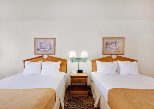 2 Betten in einem Hotelzimmer mit 2 Lampen in der Unterkunft Days Inn by Wyndham San Angelo in San Angelo