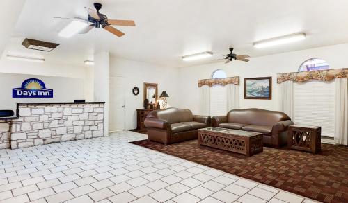 a living room with two couches and a fireplace at Days Inn by Wyndham San Angelo in San Angelo
