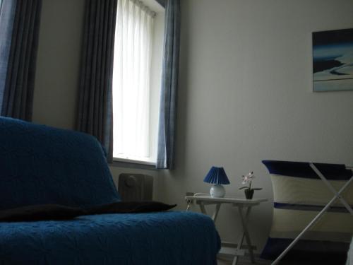 a living room with a blue couch and a window at Mikkelborg Kro in Rødding