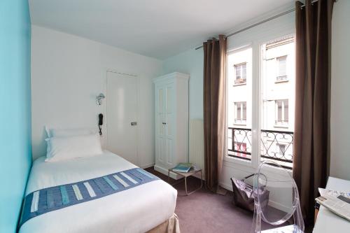 パリにあるHôtel Marais de Launayのベッドと大きな窓のある寝室