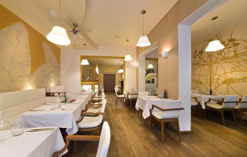 a dining room with white tables and white chairs at Hotel Art in Písek
