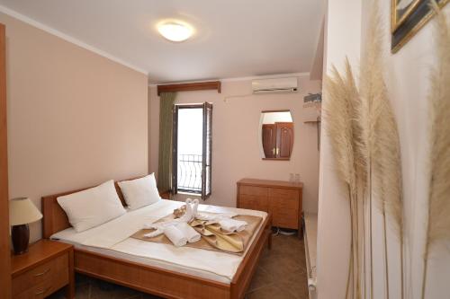 1 dormitorio con 1 cama con toallas en Hotel Anderba en Tivat