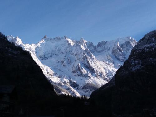 a snow covered mountain in the distance at Hotel Ottoz Meublé in Courmayeur