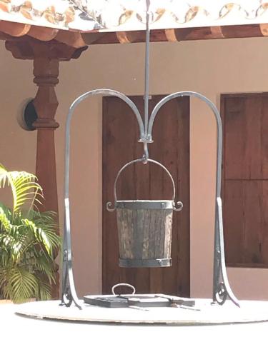 a metal bird feeder with a bucket on a table at Hotel Doña Manuela in Mompos