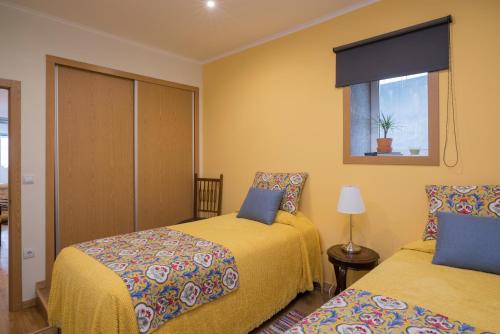 1 dormitorio con 2 camas y ventana en Casa do Cristelo, en Oporto