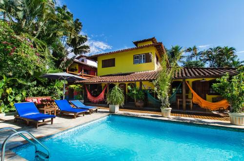 uma casa com piscina em frente a uma casa em Pousada Missanga em Paraty