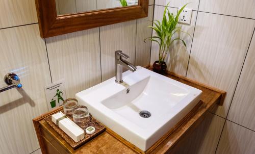 lavabo blanco en el baño con espejo en Sok Sabay Resort, en Sihanoukville