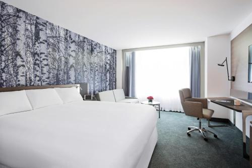 モントリオールにあるノボテル モントリオール センターのベッドとデスクが備わるホテルルームです。