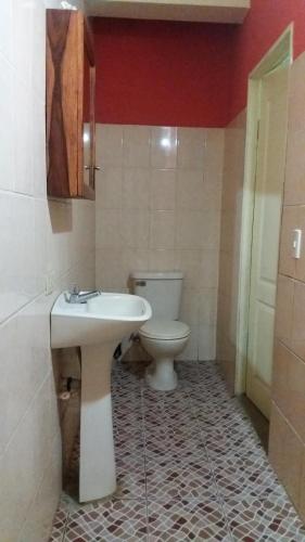 y baño con aseo blanco y lavamanos. en Hospedaje Dannita B&B en Puerto López