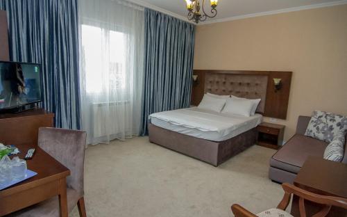 a hotel room with a bed and a living room at Hotel MaRailiS Mangalia in Mangalia