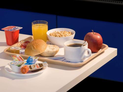 a tray of breakfast food with an apple and a cup of coffee at Ibis Budget Madrid Getafe in Getafe