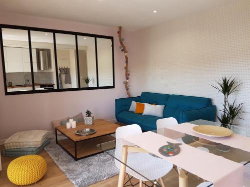 un salon avec un canapé bleu et une table dans l'établissement Apartment Cap Larros, à Gujan-Mestras