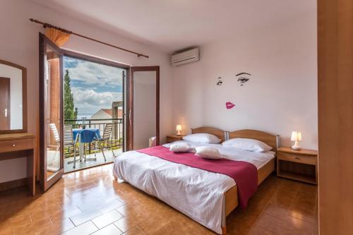 a bedroom with a large bed and a balcony at Apartmani Bezma in Bol