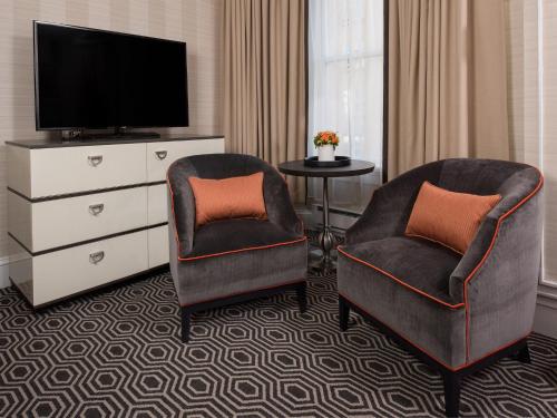 2 sillas y TV en una habitación de hotel en Inn at Union Square, en San Francisco