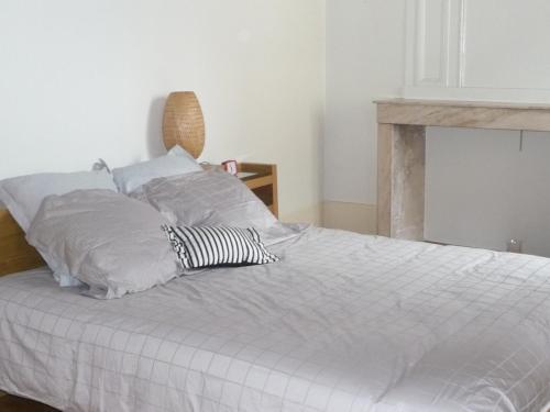 ein weißes Bett mit zwei Kissen darüber in der Unterkunft Les Charmottes in Nuits-Saint-Georges