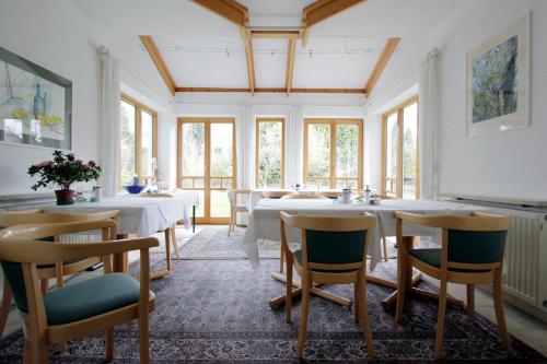 a dining room with tables and chairs and windows at Gästehaus Truckenbrodt in Wasserburg am Bodensee
