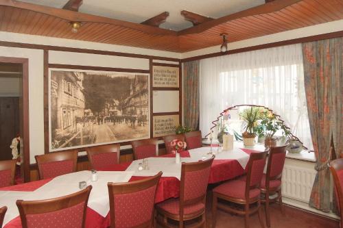 un comedor con mesa, sillas y una pintura en Hotel-Café-Restaurant Parkhaus, en Altenau