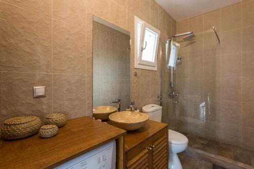 スコペロスにあるVilla Savvinaのバスルーム(洗面台2台、トイレ、シャワー付)