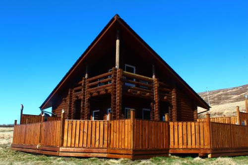 a log cabin with a wooden fence in front of it at Akureyri Log Cabin in Akureyri