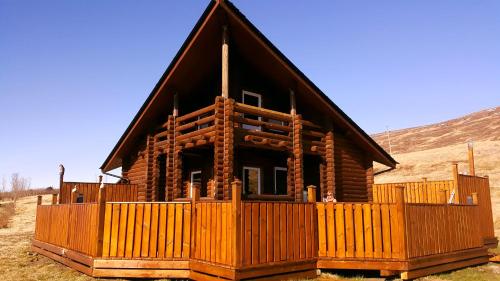 a log cabin with a fence in front of it at Akureyri Log Cabin in Akureyri