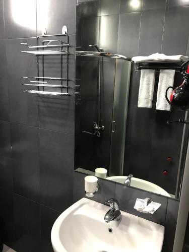 ein Badezimmer mit Waschbecken und Spiegel in der Unterkunft Hotel Condori in Kobuleti