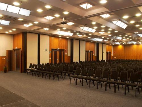 a large room with chairs and lights in it at Mercure Belo Horizonte Lourdes in Belo Horizonte