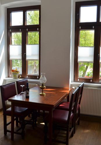 a dining room table with chairs and windows at Hotel & Café Mohrenbrunnen in Eisenberg
