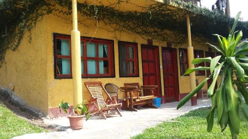 a house with two chairs and a table in front of it at El Retiro Lanquin in Lanquín