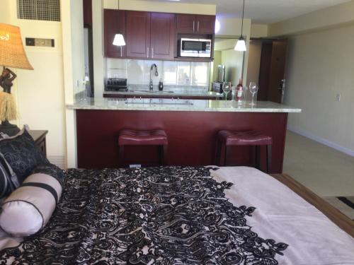 a room with a kitchen with a bed and a counter at Waikiki Ala Moana Studio 30 days in Honolulu