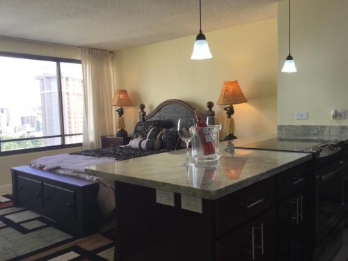 a bedroom with a bed and a kitchen with a counter at Waikiki Ala Moana Studio 30 days in Honolulu
