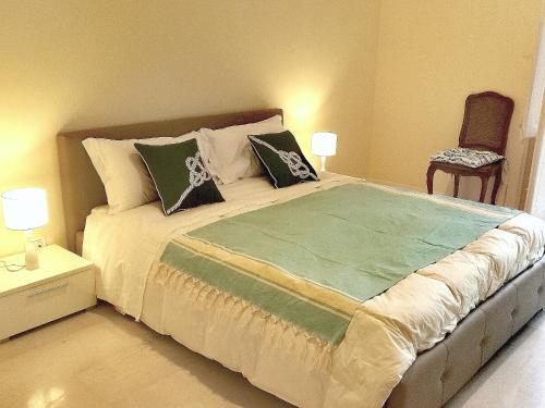 a bedroom with a large bed with pillows and a chair at Venticello Apartment in Bari