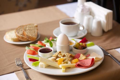 a plate of food with eggs and fruit and bread at Adelmar Hotel Istanbul Sisli in Istanbul