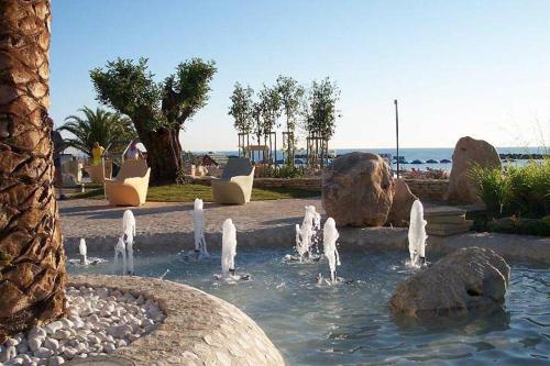 a fountain in a park with rocks in the water at Hotel Blumen in San Benedetto del Tronto