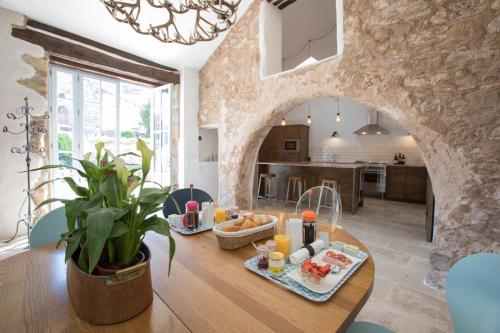 una cocina y una sala de estar con una mesa con comida. en Chateau Olmet, en Lodève