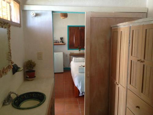 a bathroom with a sink and a room with a bed at Casa Luna Playa in Puerto Ángel