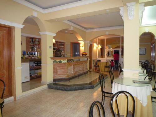 a living room with a fireplace and tables and chairs at Hotel Rompeolas in Baiona