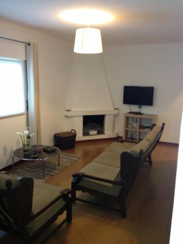 uma sala de estar com lareira e televisão em Aconchego do Lar no Gerês