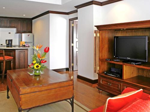 a living room with a television on a wooden entertainment center at Hotel Casa Veranda Guatemala in Guatemala