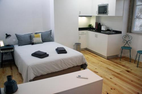 リスボンにあるDreaming Lisbon - Trigueiros Pateoの小さなベッドルーム(ベッド1台付)、キッチンが備わります。