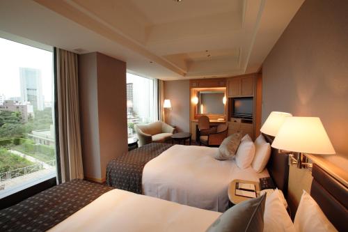 a hotel room with two beds and a large window at Hotel New Otani Tokyo The Main in Tokyo