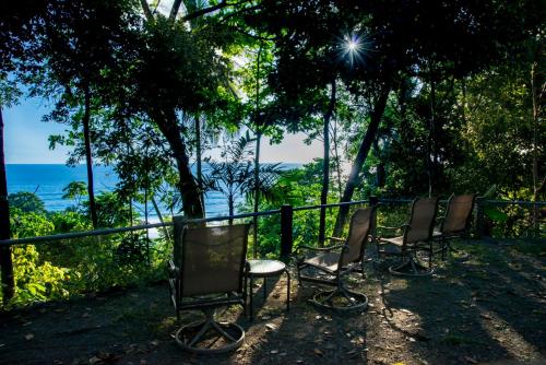 four chairs and a table in front of a fence at Tiskita Jungle Lodge in Pavones
