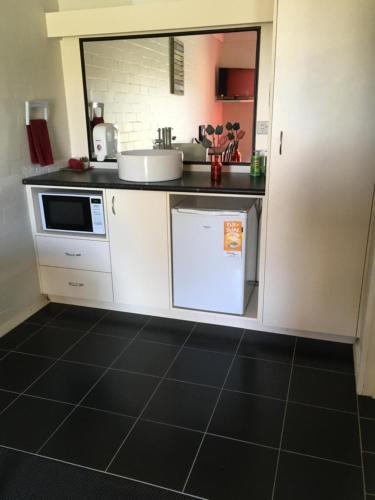 a small kitchen with a sink and a microwave at Bidgee Motor Inn in Hay